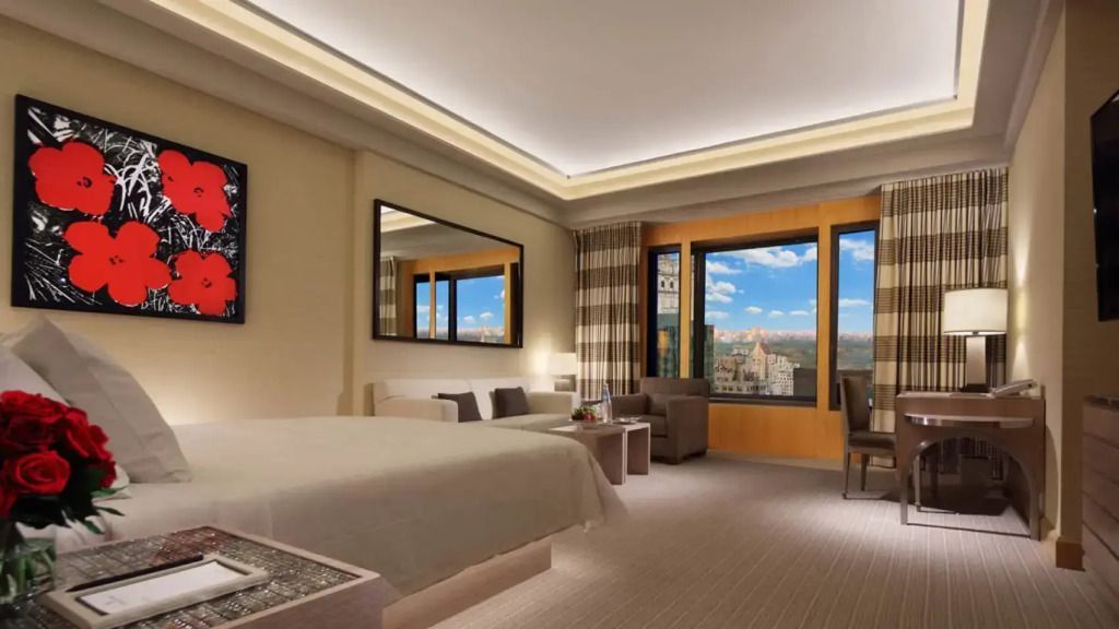 Elegante Junior-Suite mit Doppelbett und Panoramablick auf die Stadt.