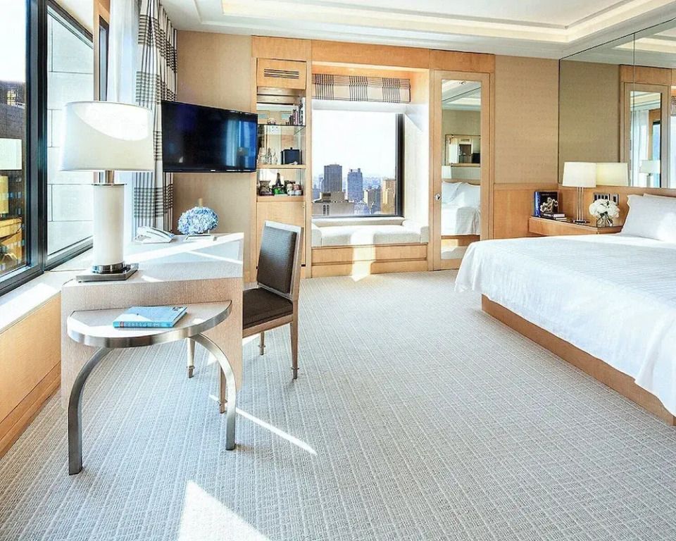Helles Zimmer mit Doppelbett, moderner Einrichtung und großem Fenster