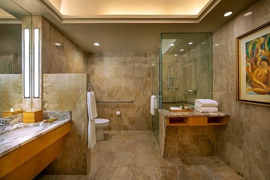 Luxuriöses Badezimmer mit Marmorfliesen und großer Dusche.