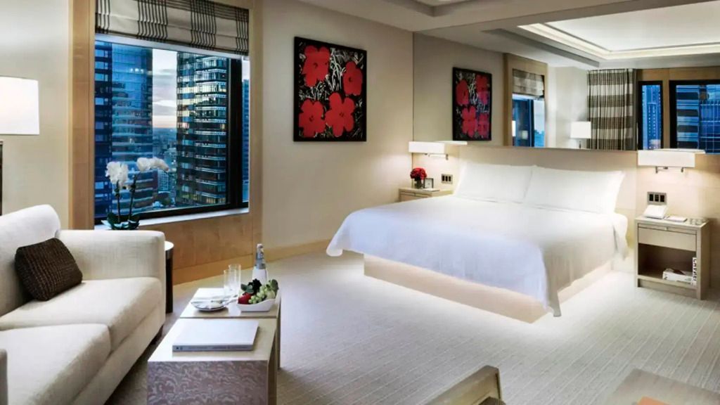 Helles Doppelzimmer mit Blick auf die Stadt durch ein großes Fenster