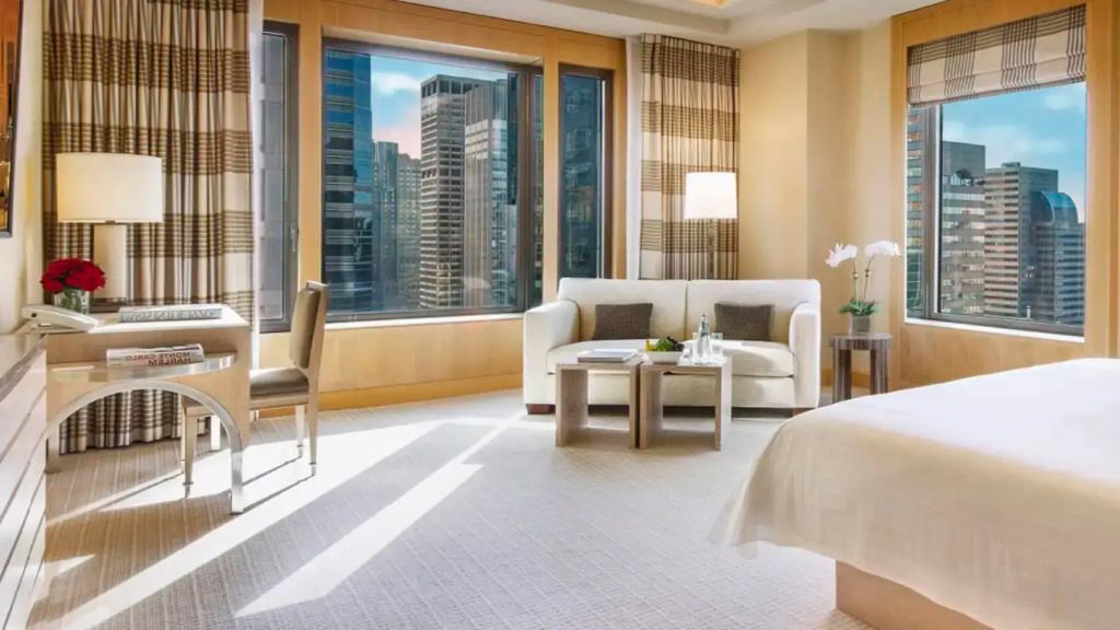 Gemütlicher Wohnbereich in einer Suite mit großen Fenstern und Stadtblick