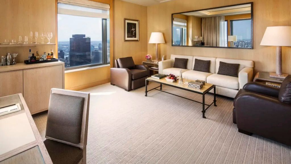 Gemütliches Wohnzimmer mit großem Sofa und Panoramafenster mit Stadtblick