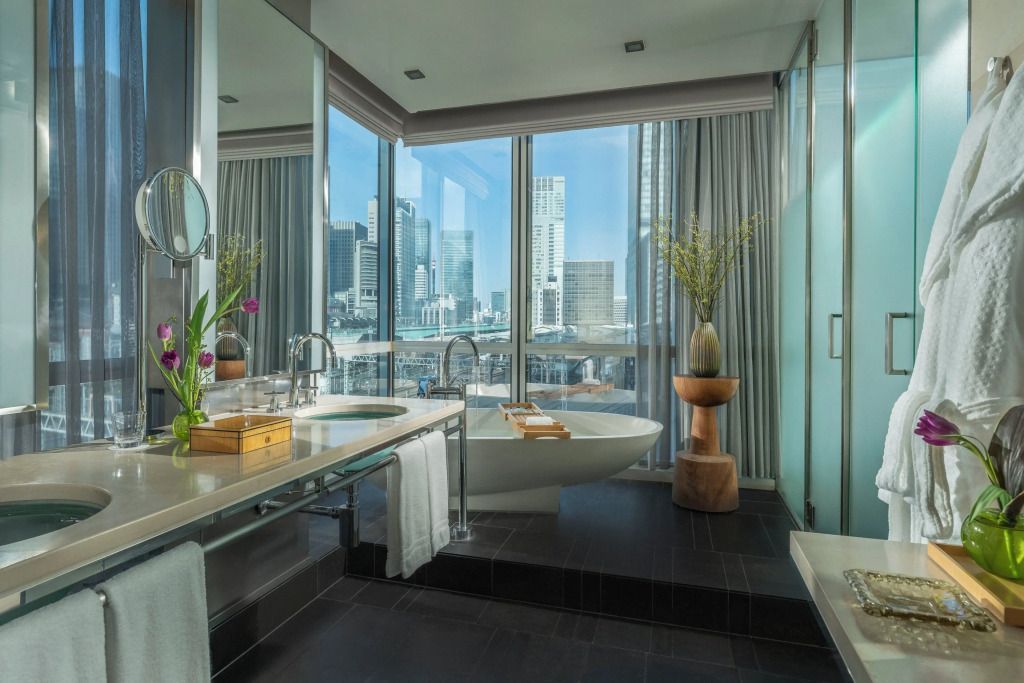 Luxuriöses Badezimmer mit freistehender Badewanne und Blick auf die Stadt in Tageslicht.