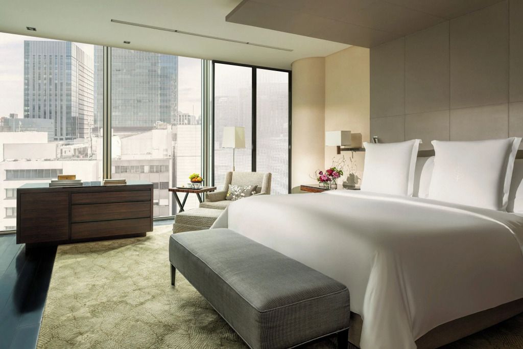 Geräumiges Zimmer mit Doppelbett und moderner Einrichtung in städtischer Umgebung.