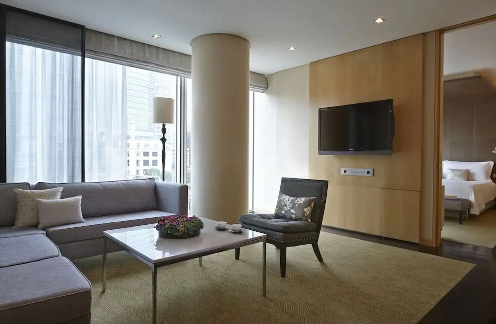 Wohnbereich der Suite mit bequemen Sofas und moderner Einrichtung im Four Seasons Hotel.