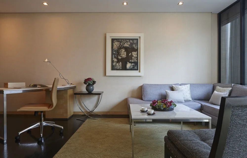 Arbeitsbereich in der Suite mit stilvollem Sofa und dekorativer Kunst an der Wand.