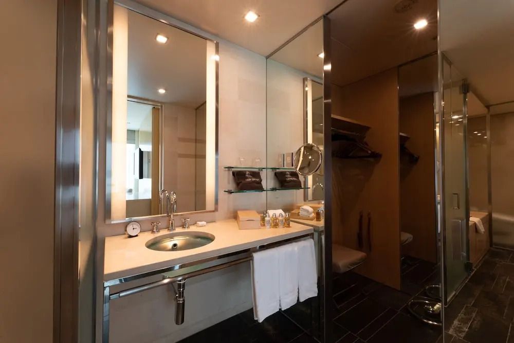 Luxuriöses Badezimmer mit großem Spiegel und gläsernen Akzenten in der Suite.