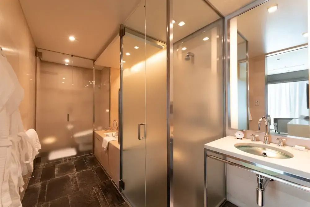 Modernes Badezimmer mit Glasdusche und hochwertigen Armaturen im Four Seasons Hotel.