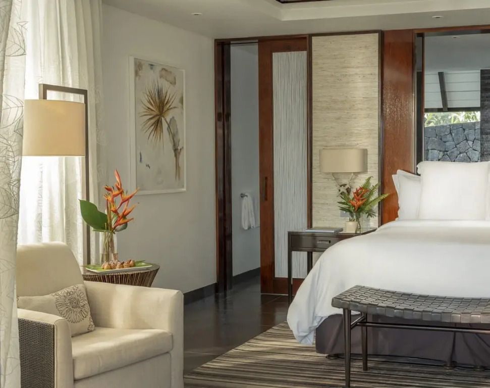Elegantes Zimmer mit zwei Einzelbetten, Sitzbereich und stilvollen Dekorationen.
