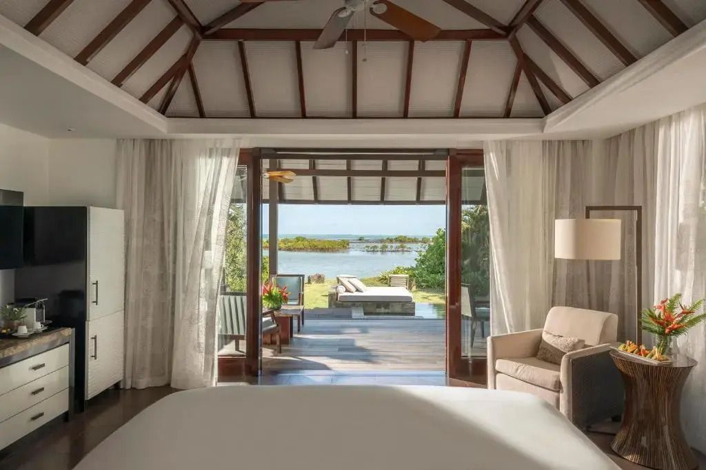 Blick aus dem Schlafzimmer auf private Terrasse und Pool mit Meerblick