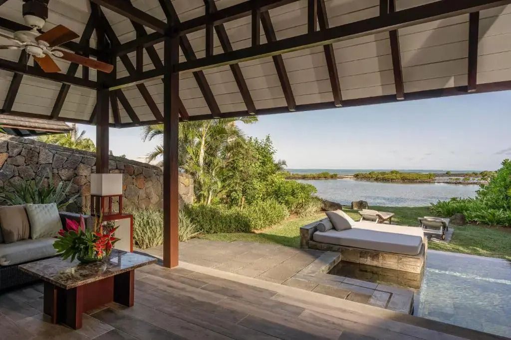 Private Terrasse mit Sitzbereich und Blick auf tropische Landschaft und Meer