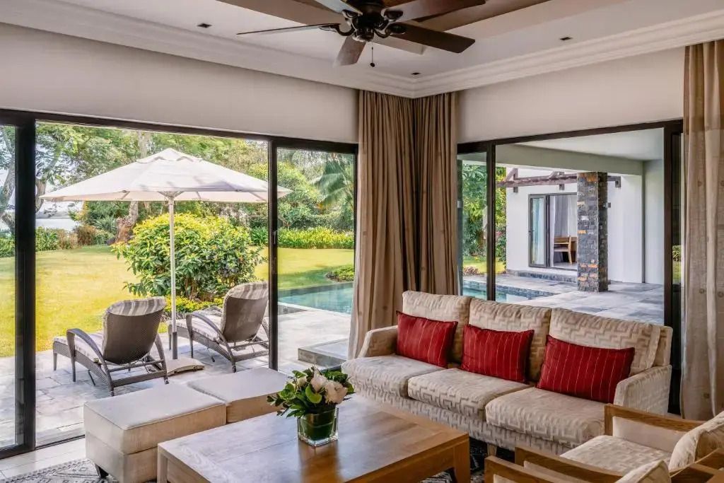 Wohnzimmer mit großen Fenstern. Zugang zu Terrasse und Pool.