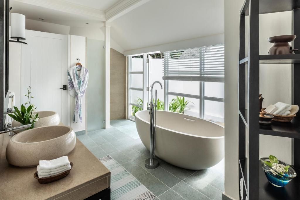 Luxuriöses Badezimmer mit freistehender Badewanne und großen Fenstern