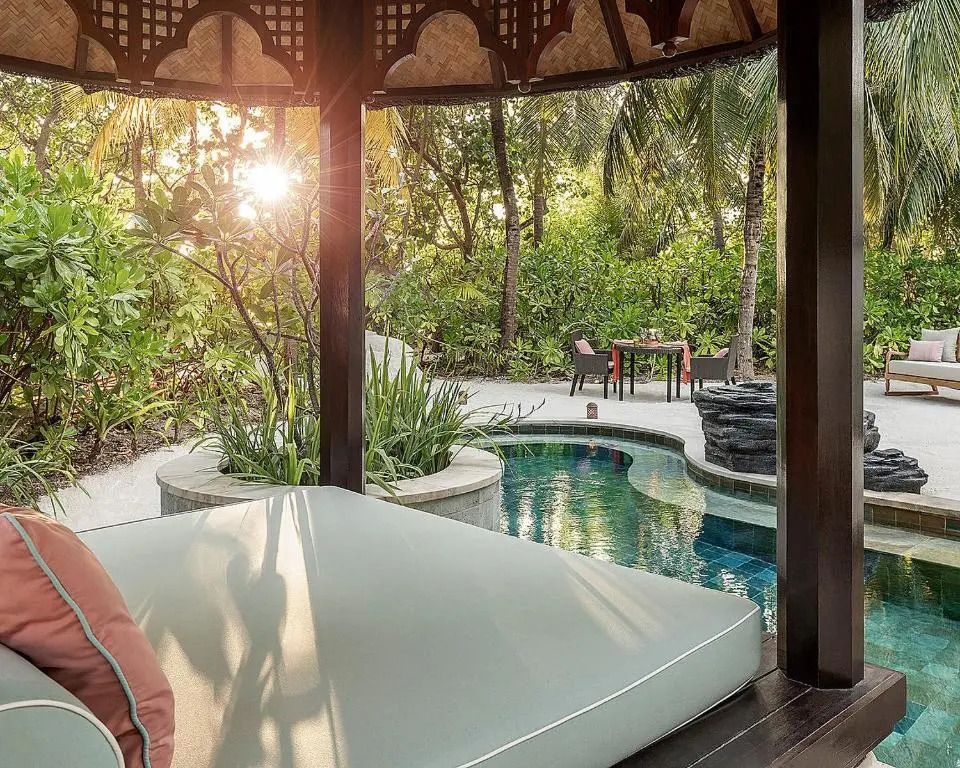 Privater Außenbereich mit Pool und Liegebereich im tropischen Garten