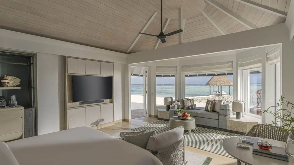 Großes Zimmer mit Meerblick, hellem Interieur und Sitzbereich.