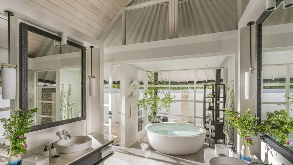 Luxuriöses Badezimmer mit freistehender Badewanne und Pflanzen.