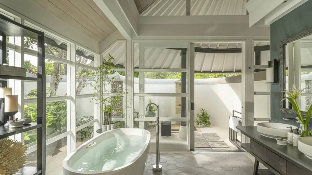 Luxuriöses Badezimmer mit freistehender Badewanne und direktem Zugang zum Garten