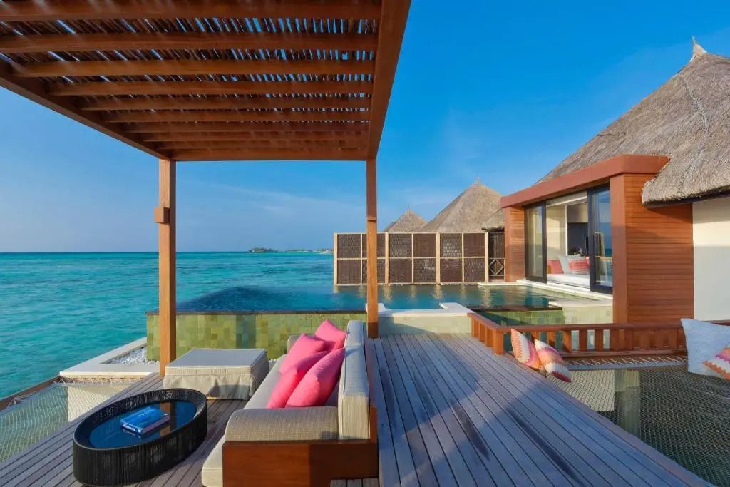 Geräumige Terrasse mit Pool und Sitzbereich vor azurblauem Ozean