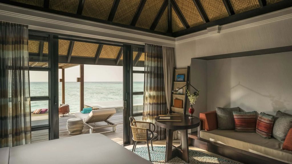 Suite mit gemütlicher Sitzecke und angrenzender Terrasse am Meer.