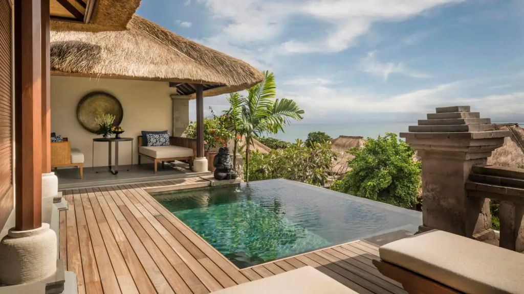 Villa mit privatem Infinity-Pool und Meerblick, umgeben von tropischen Pflanzen.