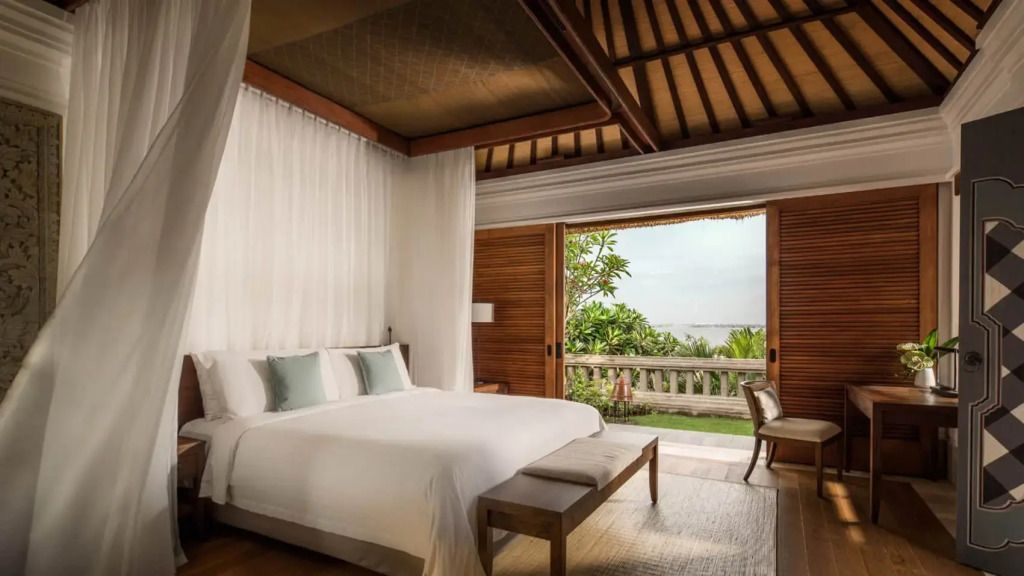 Luxuriöses Schlafzimmer mit Himmelbett und Balkonblick auf tropische Gärten