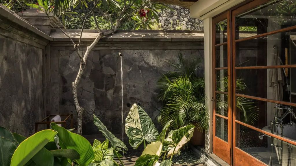 Privater Gartenbereich mit exotischen Pflanzen und Steinmauer
