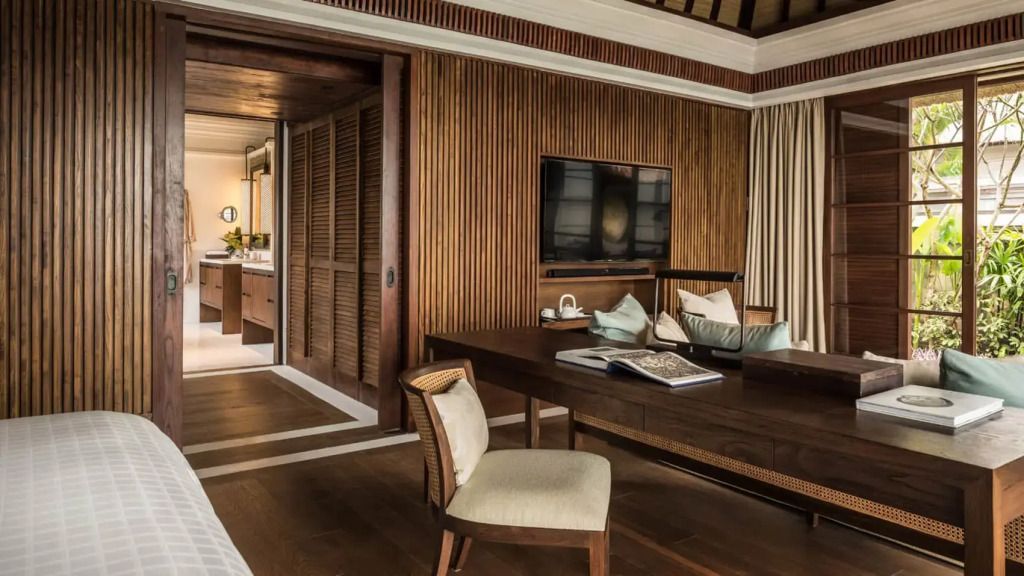 Holzverkleidetes Zimmer mit Schreibtisch und modernem Fernseher
