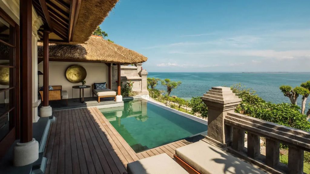 Privater Pool der Villa mit Blick auf das Meer und traditionelle balinesische Architektur