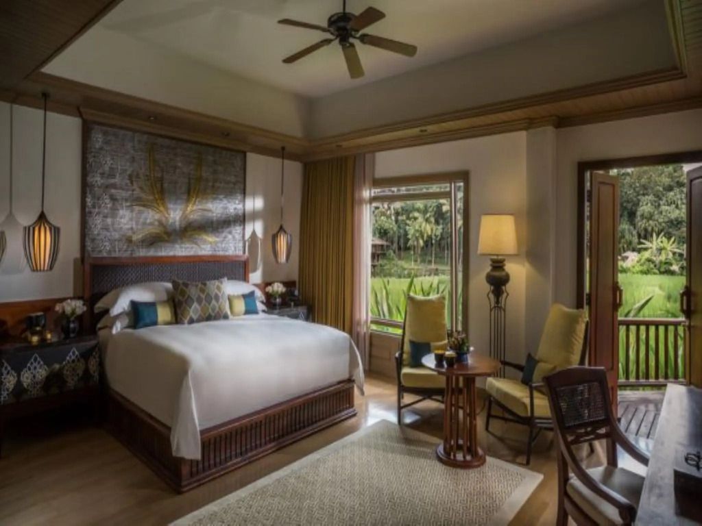 Luxuriöses Schlafzimmer mit Doppelbett im Four Seasons Resort Chiang Mai mit Gartenblick