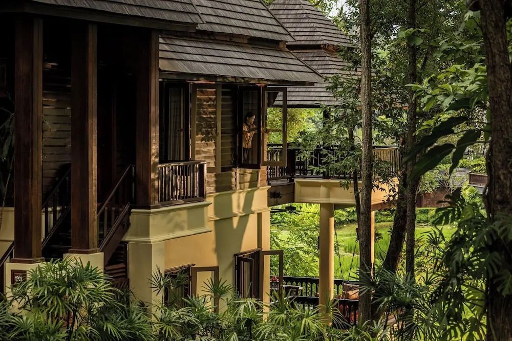 Traditionelle Thai-Architektur mit Balkonen im Four Seasons Resort Chiang Mai inmitten von Pflanzen