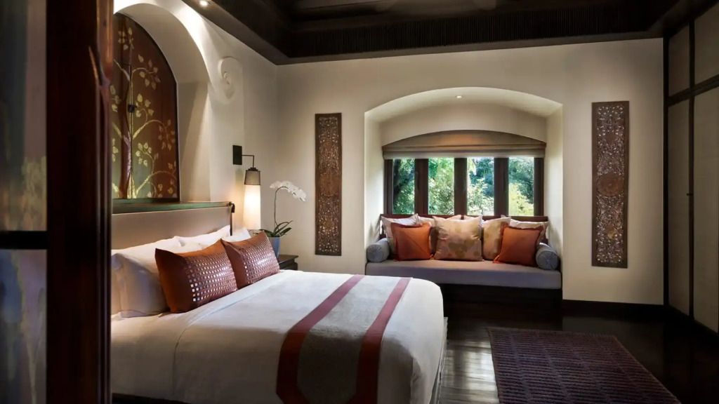 Großzügiges Schlafzimmer mit Doppelbett und gemütlicher Fenstersitzbank mit Gartenblick
