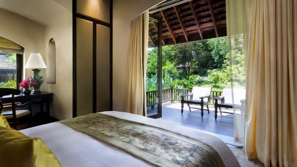 Schlafzimmer mit offenem Zugang zur Terrasse und Blick auf tropische Vegetation
