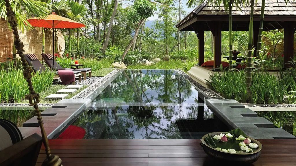 Privater Infinity-Pool mit Blick auf tropische Vegetation und entspannende Liegeflächen