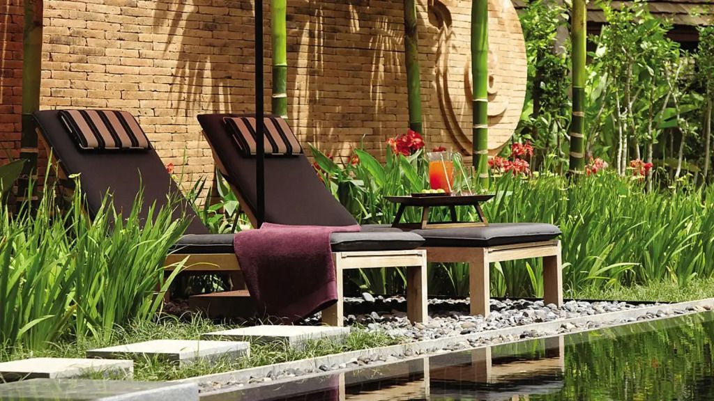 Sonnenliege neben dem privaten Pool umgeben von üppigen grünen Pflanzen
