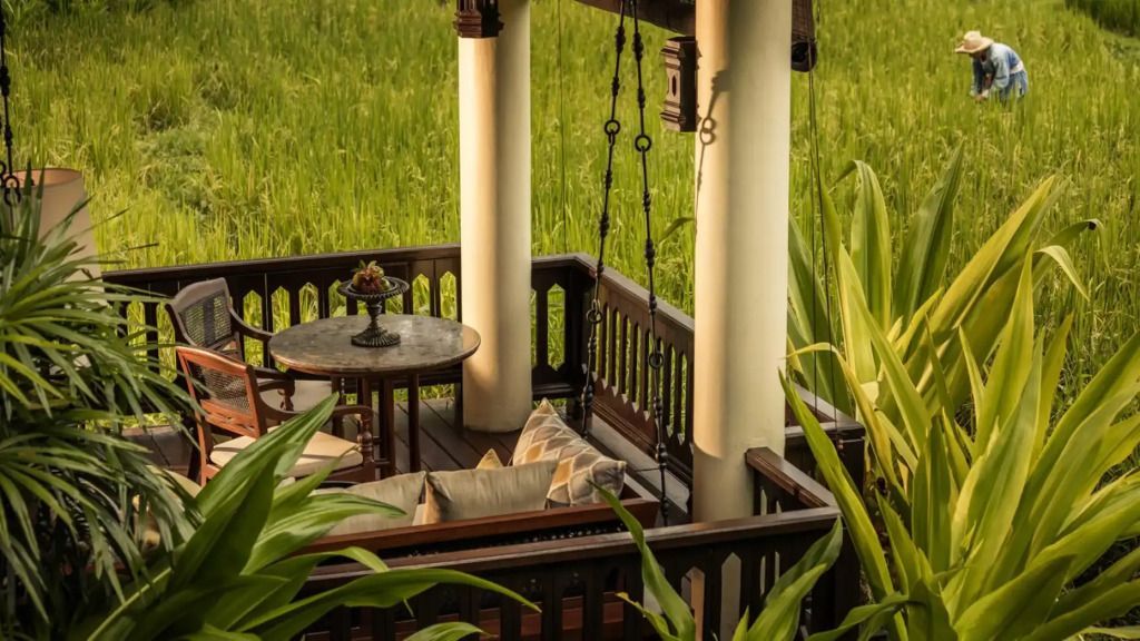 Private Terrasse mit Sitzbereich und Blick auf grüne Reisfelder im Four Seasons Resort Chiang Mai