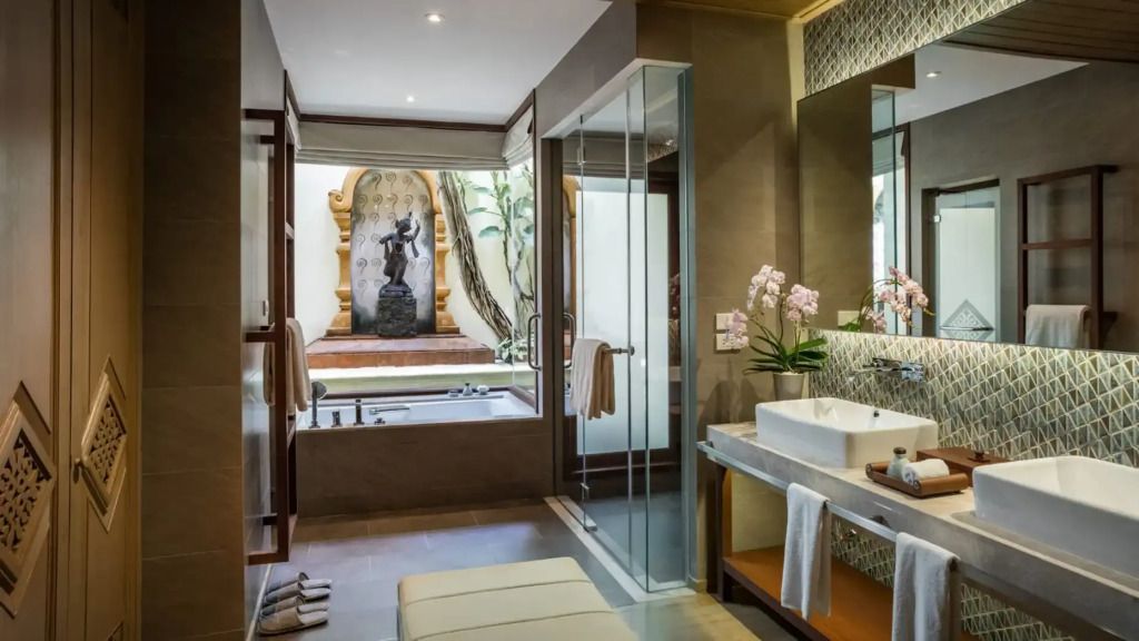 Modernes Badezimmer mit großer Badewanne und Balinesischer Statue für ein entspannendes Ambiente