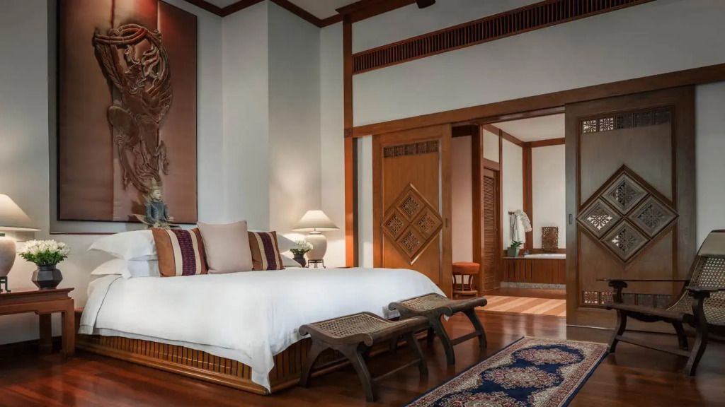 Geräumiges Schlafzimmer mit dekorativen Holzelementen im Four Seasons Resort Chiang Mai