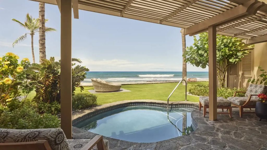 Privater kleiner Pool mit Blick auf das Meer umgeben von grüner Landschaft und Palmen