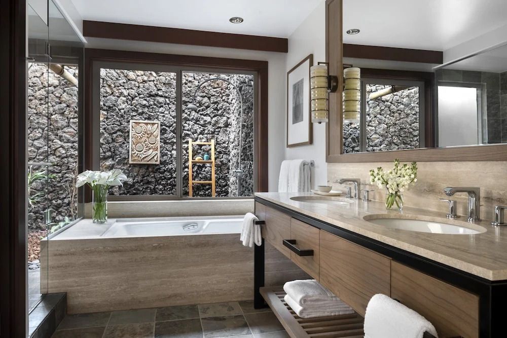 Moderne Badezimmer mit Badewanne und Steinwand-Ausblick.