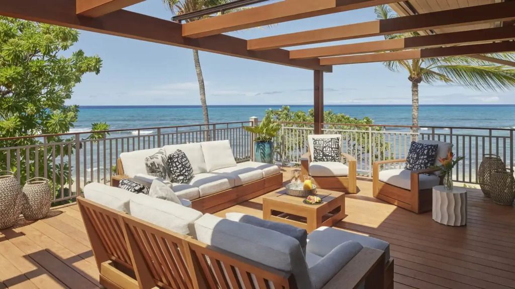 Überdachte Terrasse mit bequemen Sofas und Blick auf Ozean