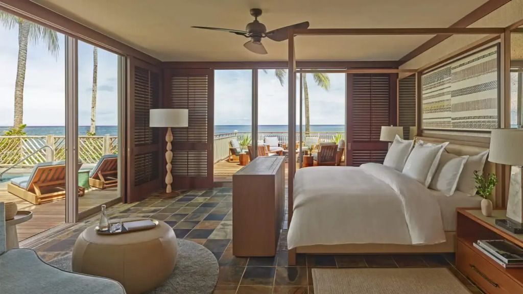 Helle Villa-Suite mit großem Bett und Terrasse mit Meerblick