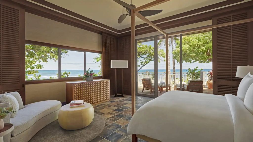Luxuriöses Schlafzimmer in einer Suite mit Blick auf das Meer und stilvollen Holzmöbeln