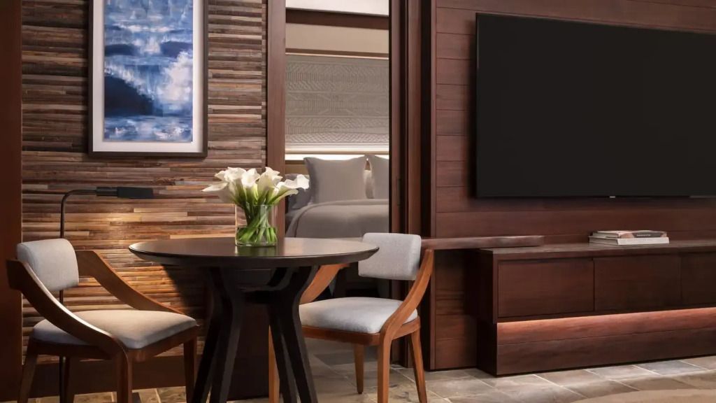 Elegantes Hotelzimmer mit Doppelbett, stilvollem Holzmobiliar und Kunst an den Wänden