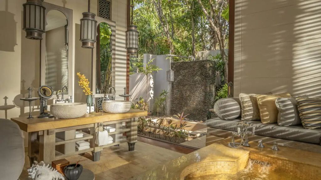 Luxuriöses Badezimmer mit Doppelwaschbecken, Natursteinelementen und Blick ins Grüne