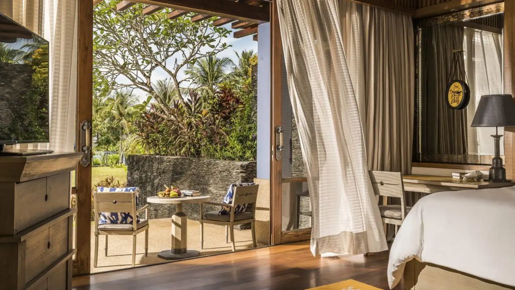 Terrasse mit Sitzbereich umgeben von tropischen Pflanzen am Zimmer