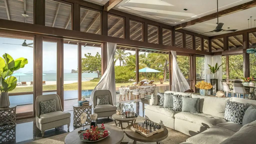Geräumige Lounge mit Blick auf Garten und Meer im Hintergrund