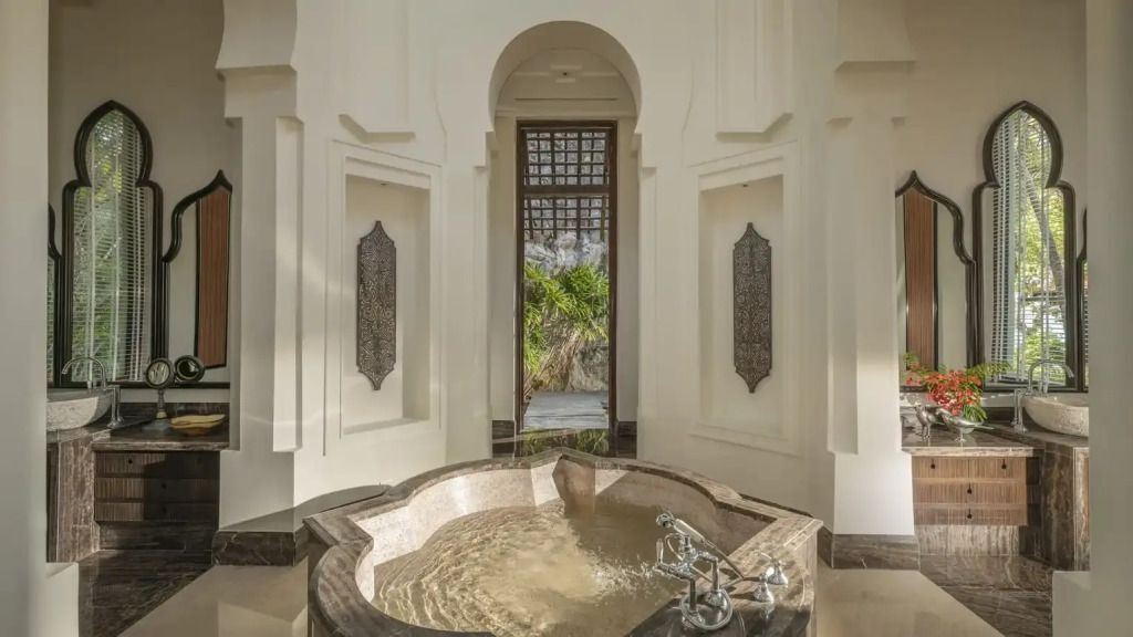 Exquisites Badezimmer mit großer eingelassener Badewanne und eleganter Dekoration