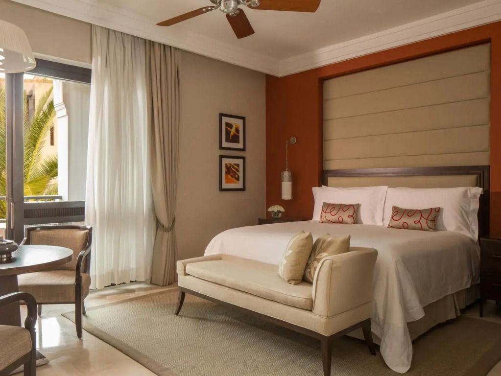 Geräumiges Zimmer mit Doppelbett, Sitzbereich und Deckenventilator