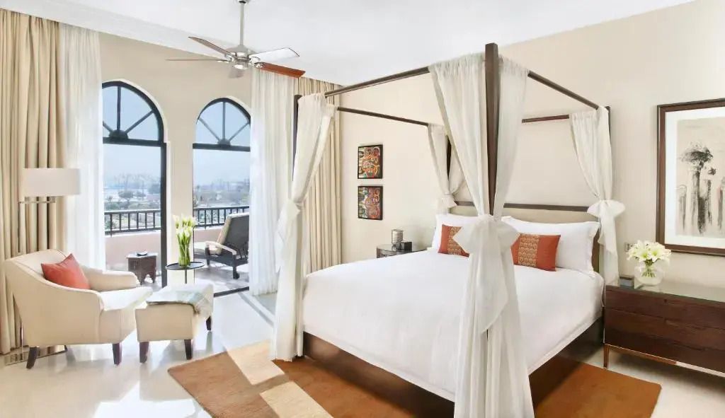 Geräumiges Schlafzimmer mit Himmelbett und Balkon im Four Seasons Resort Marrakech.