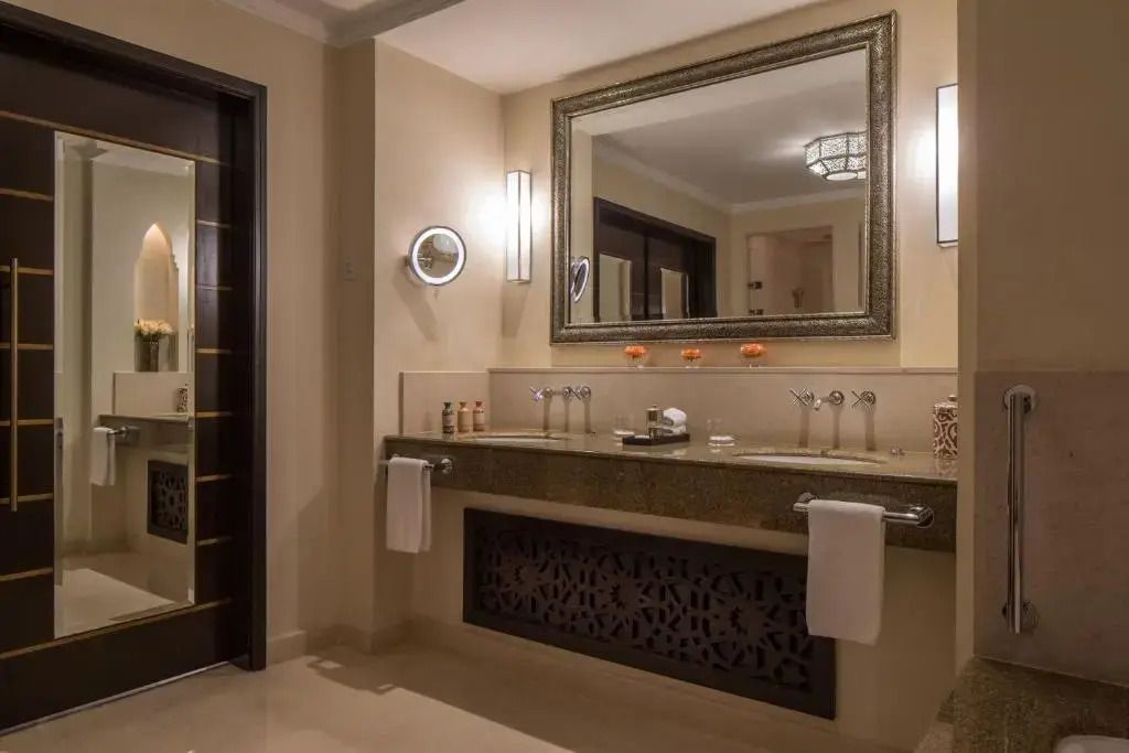 Modernes Badezimmer mit großem Spiegel und dezenter Beleuchtung.